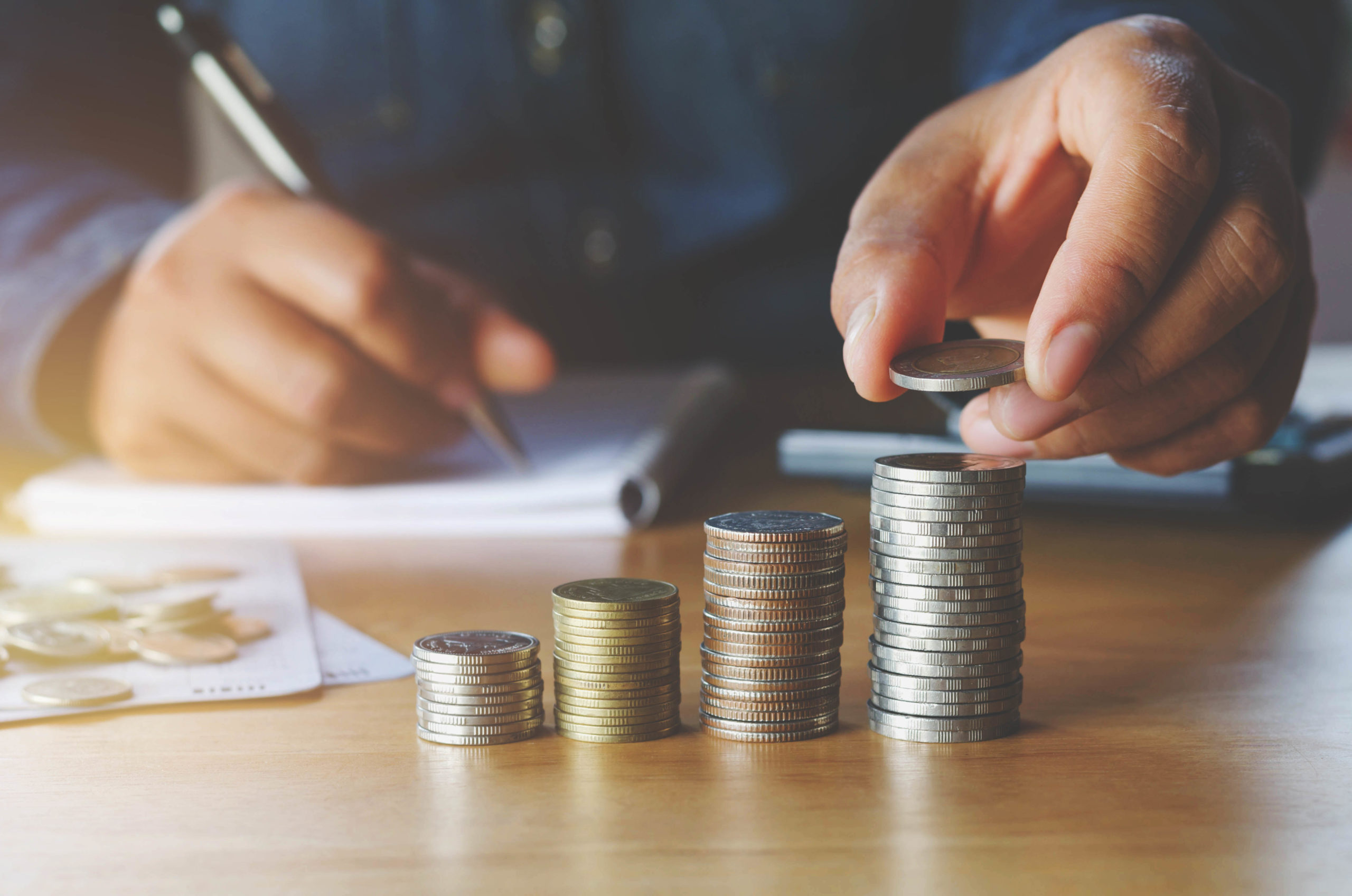 business accounting with saving money with hand putting coins on stack concept financial