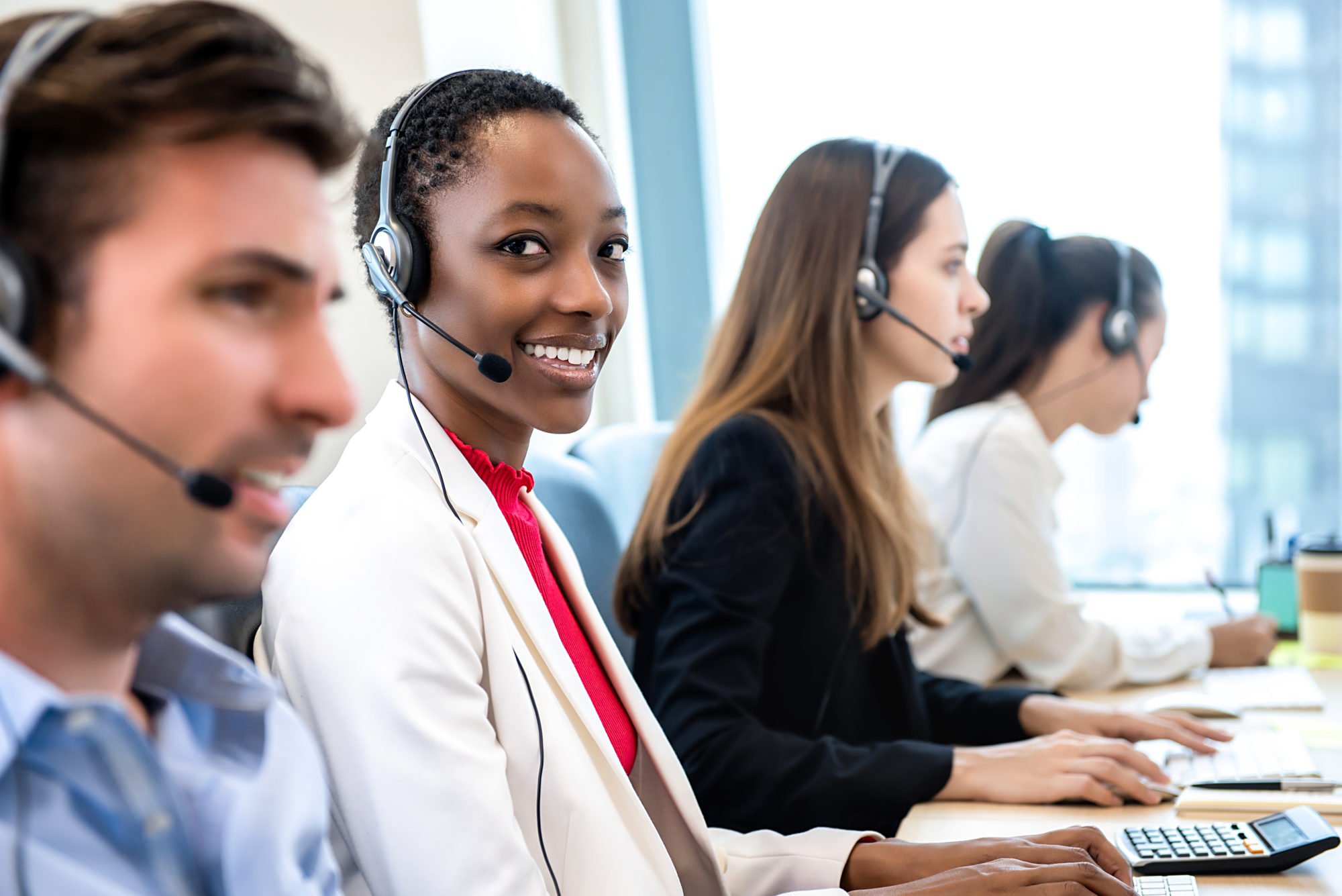 Smiling beautiful African American woman working in call center with ...