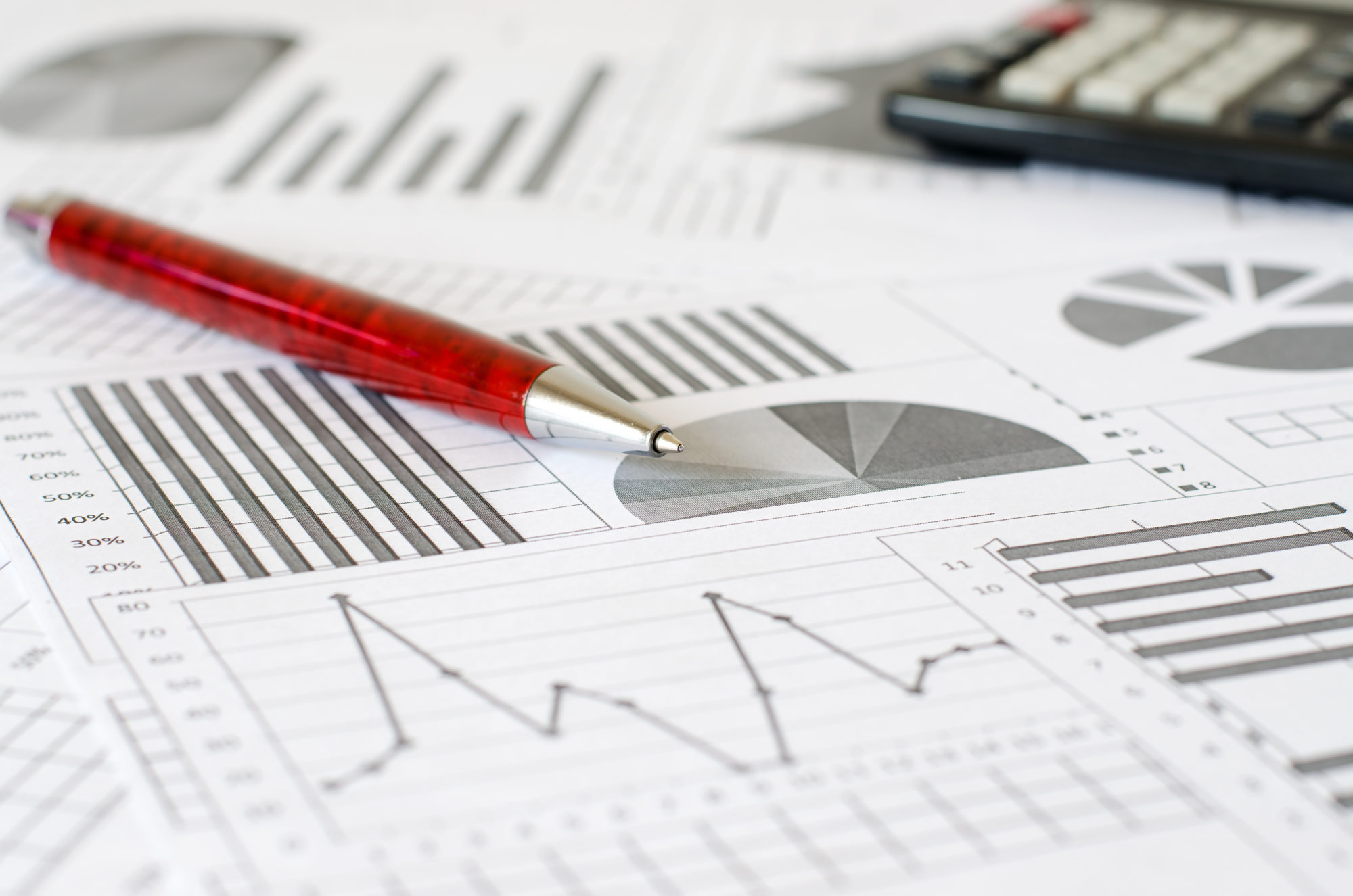 Business analytics, graphs and charts. A schematic drawing on paper. Ballpoint pen and calculator annuity quote printout